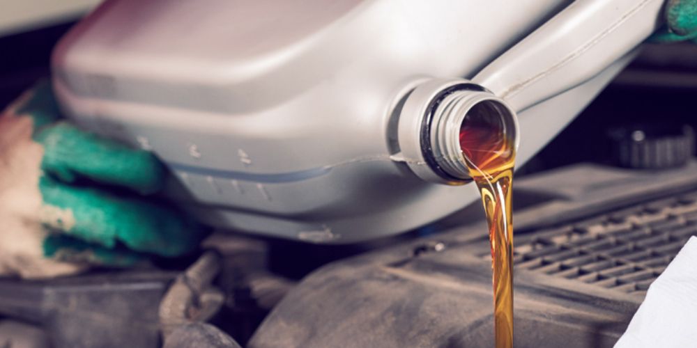 Mechanic pouring engine oil into a vehicle - MOT Testing Gateshead